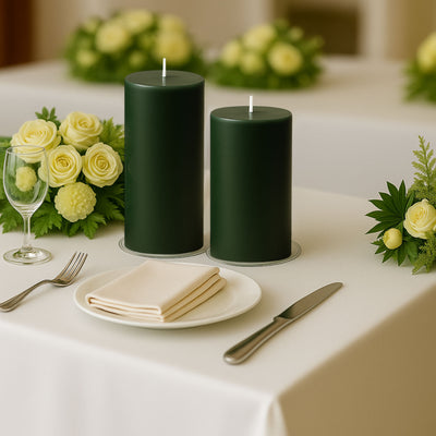 Green candles with floral arrangement on a dining table setting.