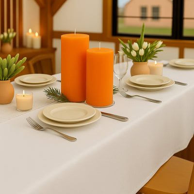Elegant dining table setup with orange candles and minimalist decor.