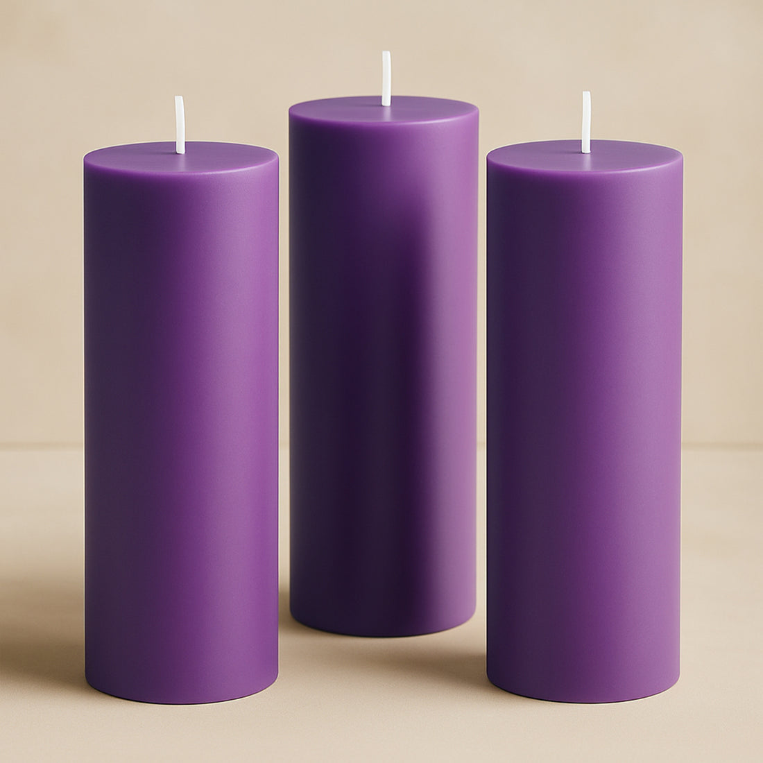 Purple pillar candles in varying heights against a soft beige backdrop.