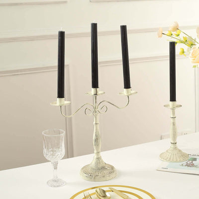 Elegant silver candelabra with three black candles on a dining table.