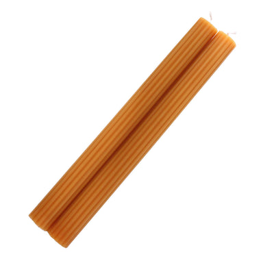 Two orange ribbed candles on a plain white background