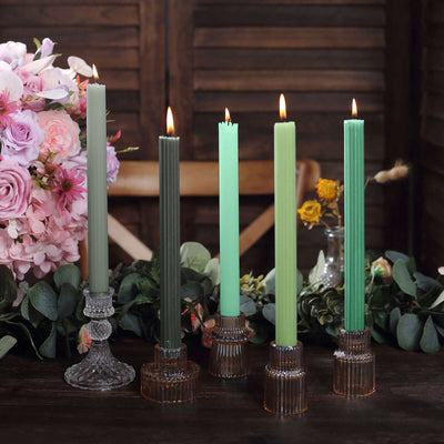 Colorful taper candles in stylish holders with floral decor.