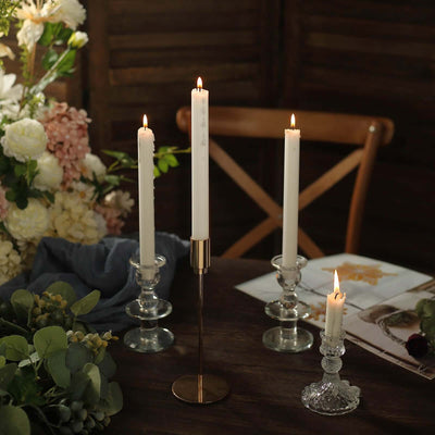 Elegant candle holders with white candles on a rustic table setting.