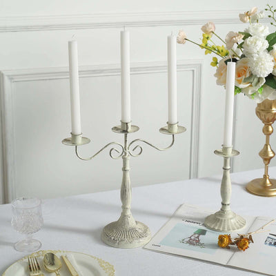Elegant vintage candle holder with four white candles on a dining table.