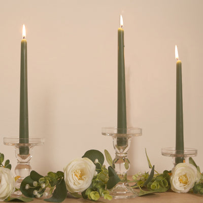 Green taper candles in clear holders with floral accents