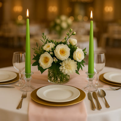 Elegant table setting with green candles and floral centerpiece.