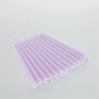 Set of lavender taper candles on a plain background