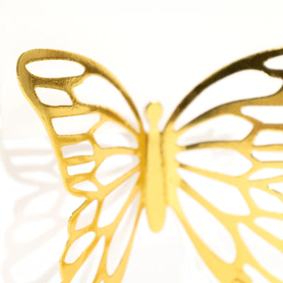Golden butterfly decoration with intricate cutout design.
