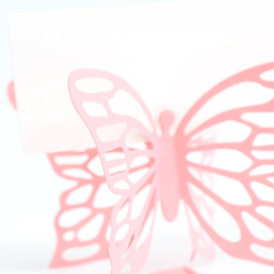 Pink butterfly paper cutout on a white background.