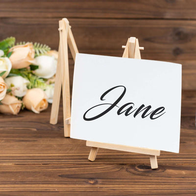 Personalized name card displayed on an easel with floral backdrop.