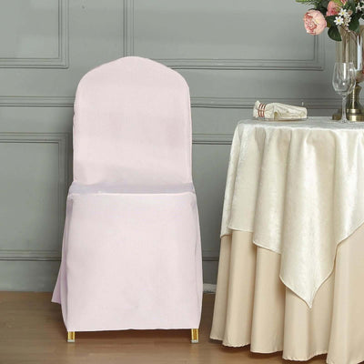 Pink chair cover draped on a chair beside a table setting.