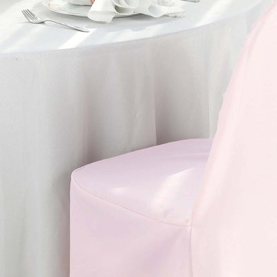 Pink chair cover draped over a chair at a dining table.