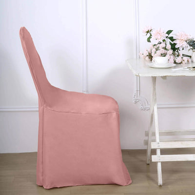 Pink chair cover draped on a chair next to a table with flowers.