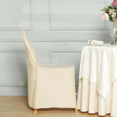 Elegant beige chair next to a dining table with a white tablecloth.