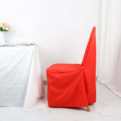 Red chair cover on a dining chair beside a table with a white tablecloth.