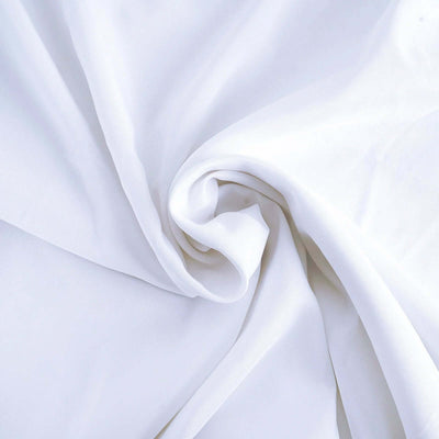 White fabric draped in soft folds showcasing its smooth texture.