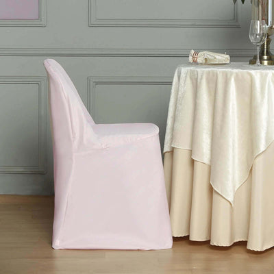 Pink chair cover draped on a chair beside a table with a tablecloth.