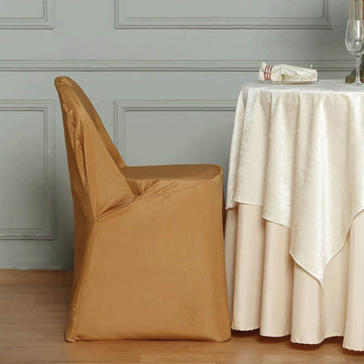Gold chair cover draped over a chair next to a table with a tablecloth.