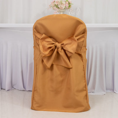 Elegant gold chair cover with large bow detail for event decor.