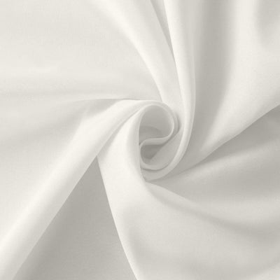 White fabric with a smooth texture, gently folded in a swirl pattern.