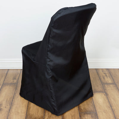 Black chair cover on a wooden floor, showcasing its sleek design and fabric texture.