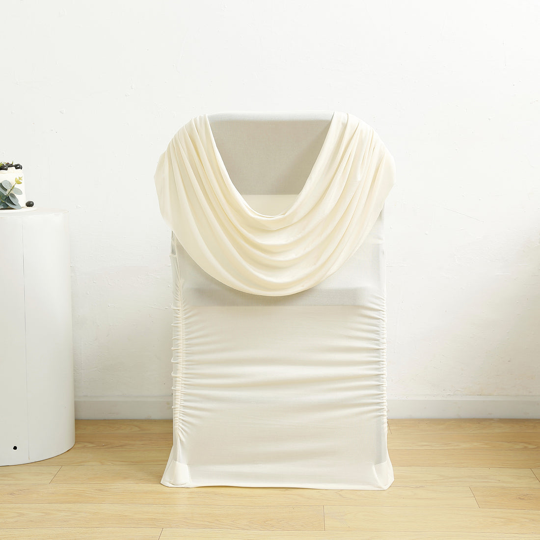 Cream draped chair cover on a white backdrop