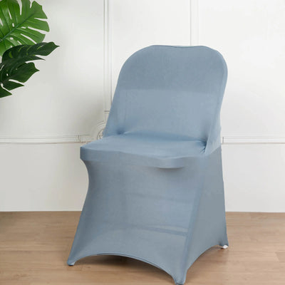 Gray stretch chair cover on a wooden floor with a plant backdrop.