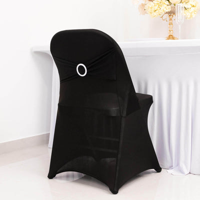 Black chair cover with decorative bow for event styling.