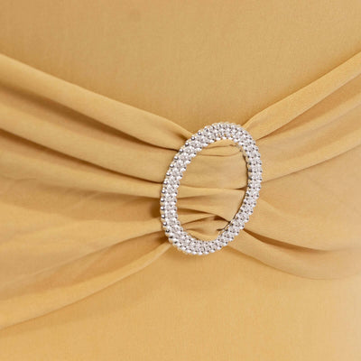 Elegant yellow dress detail featuring a sparkling rhinestone brooch.