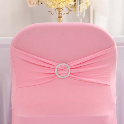 Pink chair cover with decorative rhinestone ring detail.