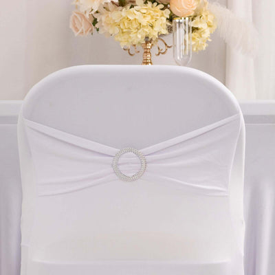 White chair cover with decorative rhinestone accent.