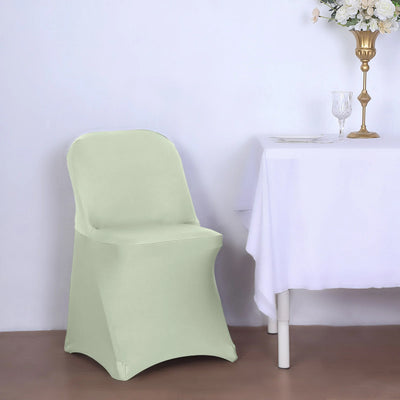Mint green chair cover on a chair beside a table with a white tablecloth.