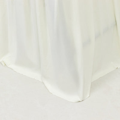 White satin tablecloth draping elegantly over a table edge.