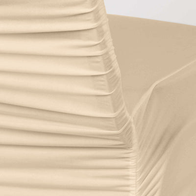 Stacked cream fabric layers with a folded upholstered corner close-up