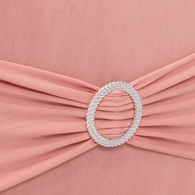 Pink dress with ruched detailing and silver circular embellishment.