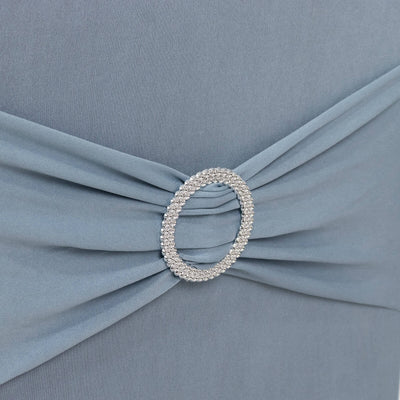Elegant blue dress detail with sparkling circular brooch.