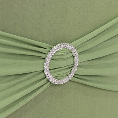 Green dress with jeweled belt detail on a plain background.