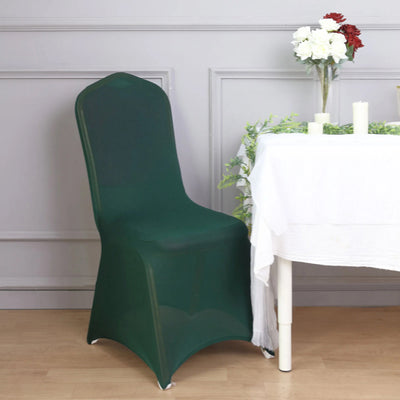 Green chair cover on a table with flowers and candles in a styled setting.
