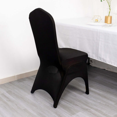 Black chair with a sleek design positioned beside a table.