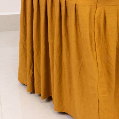 Pleated mustard yellow fabric draping elegantly from a table.