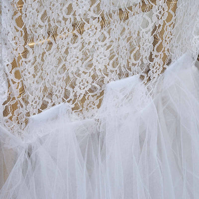 White lace and tulle fabric close-up with delicate floral patterns.