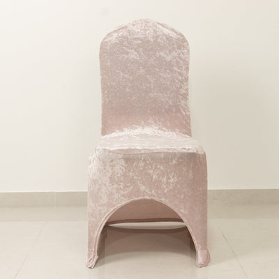 Pink velvet dining chair with arched base on a plain background.