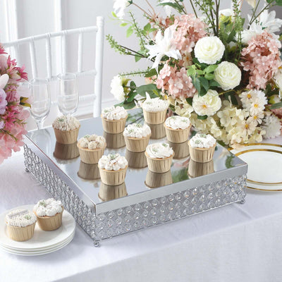 Decorative cake stand with floral cupcakes and elegant table setup.