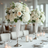 Elegant floral arrangements in crystal vases for a wedding reception setting.
