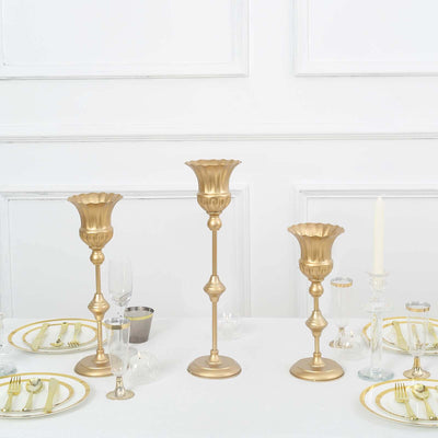 Elegant gold candlesticks on a dining table set for a formal meal.
