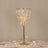 Elegant crystal chandelier table lamp with gold accents.