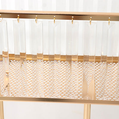 Gold metallic console table with clear acrylic hanging accents.