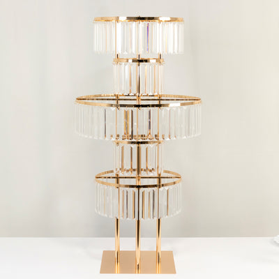 Gold and crystal chandelier with three tiers on a plain background