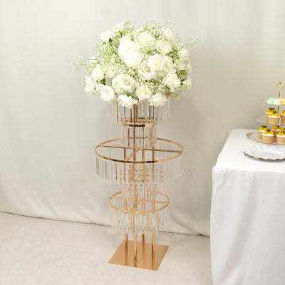 Elegant floral centerpiece on a gold stand with cascading crystals.