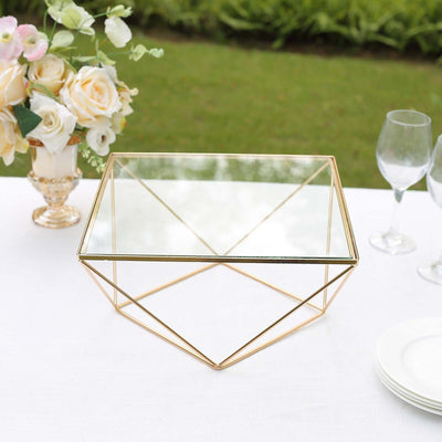 Geometric glass-top coffee table with gold metal frame in outdoor setting.